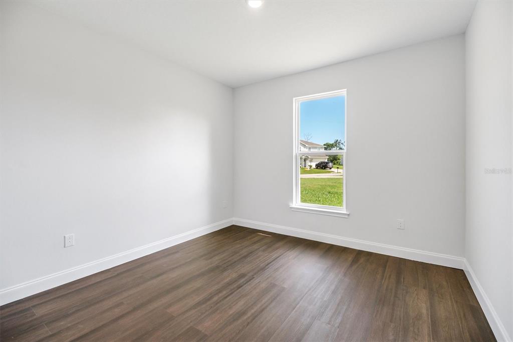 52 Pershing Lane Palm Coast, FL 32164 - Photo 24 of 37 a view of an empty room with wooden floor and a window