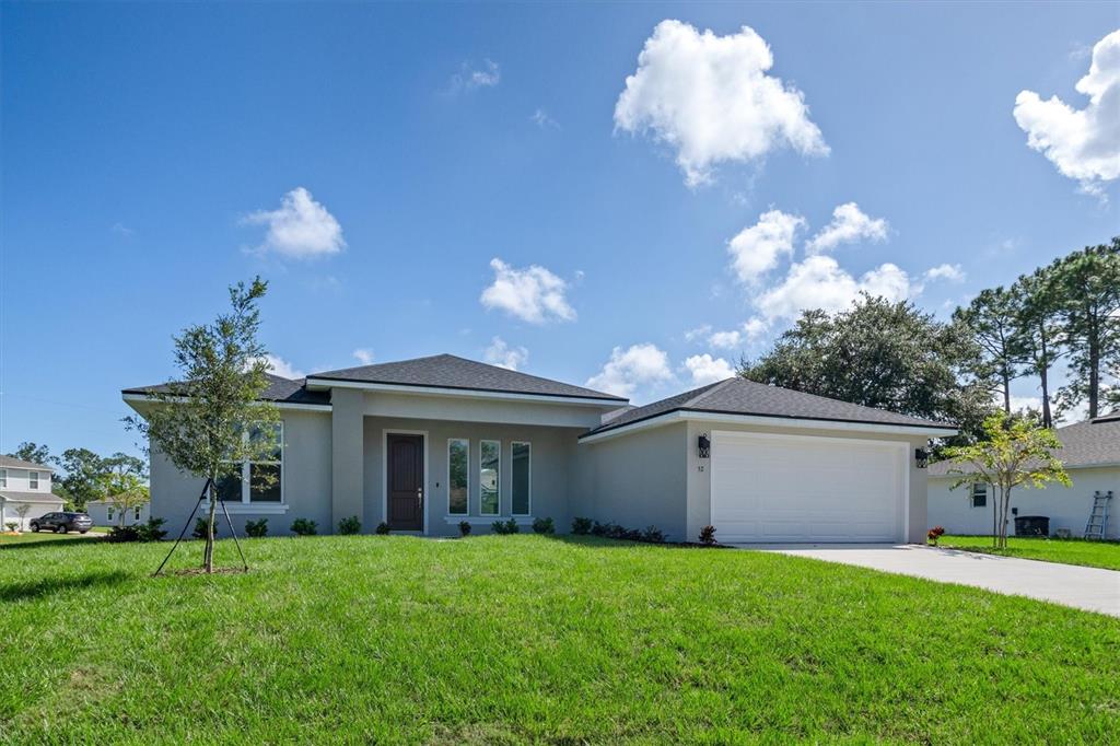 52 Pershing Lane Palm Coast, FL 32164 - Photo 6 of 37 a view of a house with big yard and a large tree