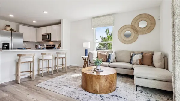 a living room with stainless steel appliances kitchen island granite countertop furniture and a wooden floor