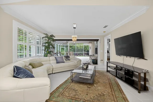 a living room with furniture a flat screen tv and a large window