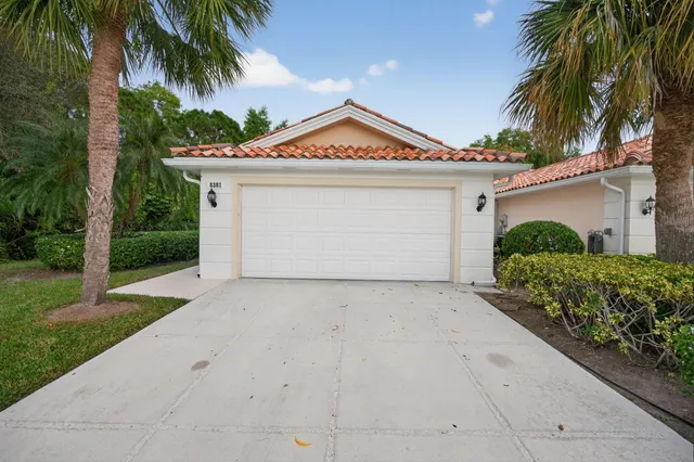 a view of a house with a yard and palm trees
