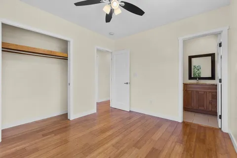 an empty room with a hardwood and ceiling fan