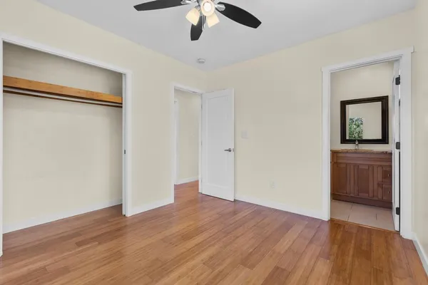 an empty room with a hardwood and ceiling fan