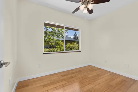 an empty room with a window and a ceiling fan