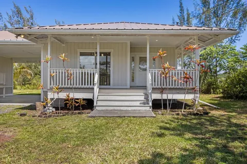 a front view of a house with a garden and porch