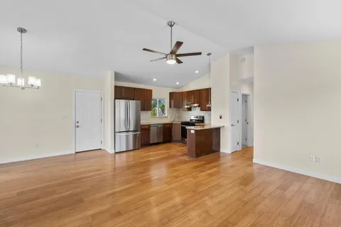 a large kitchen with cabinets wooden floor and stainless steel appliances