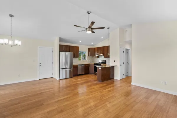a large kitchen with cabinets wooden floor and stainless steel appliances