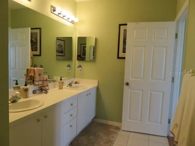 a spacious bathroom with a double vanity sink a mirror and shower