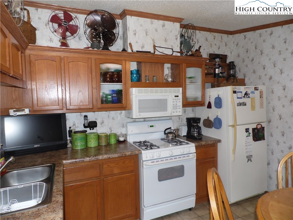 528 Stewart Road Ennice, NC 28623 - Photo 14 of 46 a kitchen with stainless steel appliances a stove a sink and a microwave