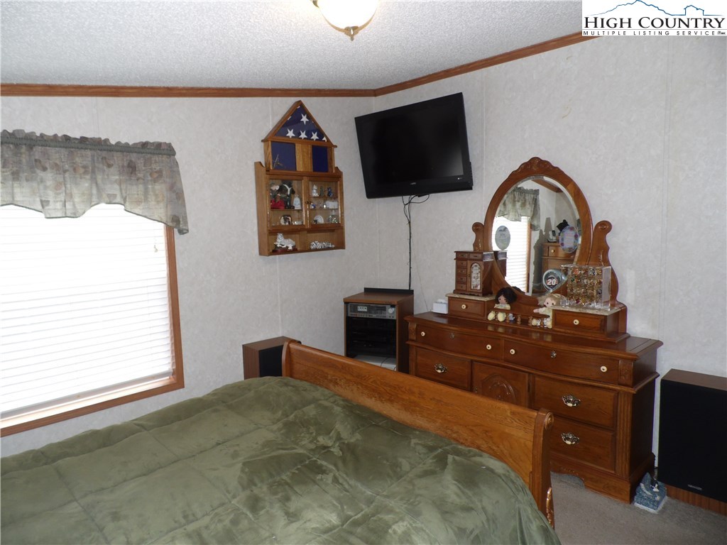 528 Stewart Road Ennice, NC 28623 - Photo 15 of 46 a bedroom with a bed and a flat screen tv