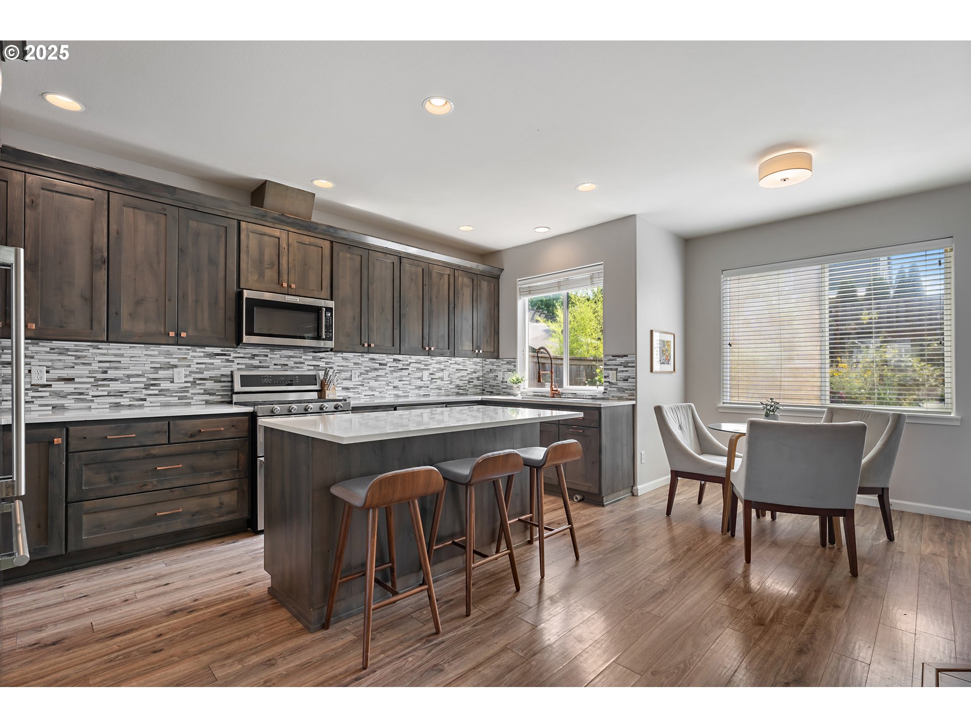 15702 Southwest Snowy Owl Lane Beaverton, OR 97007 - Photo 7 of 44 a kitchen with stainless steel appliances granite countertop a stove top oven a sink dishwasher a dining table and chairs with wooden floor
