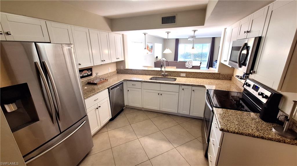 910 Vanderbilt Beach Road, Unit 416E Naples, FL 34108 - Photo 6 of 16 a kitchen with stainless steel appliances granite countertop a refrigerator and a sink