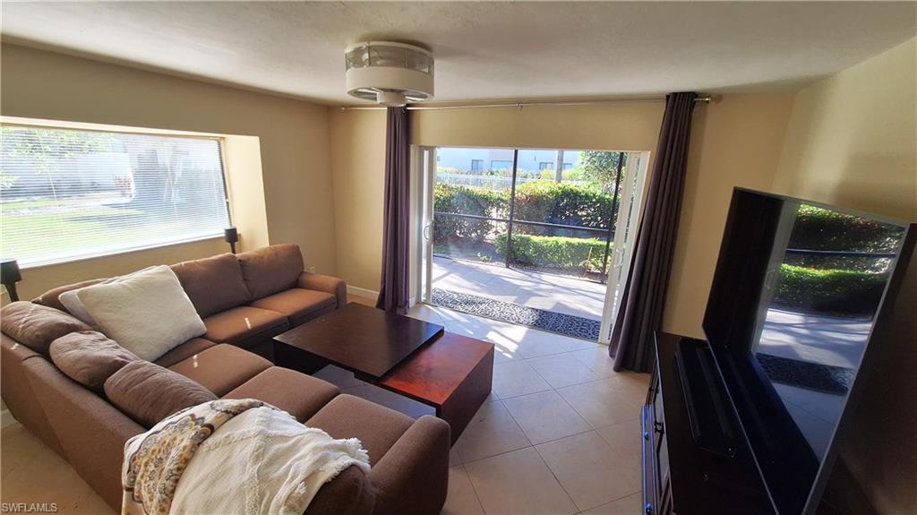 910 Vanderbilt Beach Road, Unit 416E Naples, FL 34108 - Photo 8 of 16 a living room with furniture and a floor to ceiling window