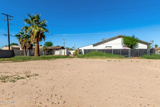 a view of a house with a yard and palm trees