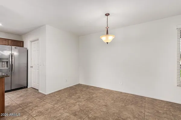 a kitchen with stainless steel appliances granite countertop a sink a stove a refrigerator cabinets and a dining table