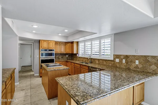 a bathroom with a granite countertop sink a toilet and shower