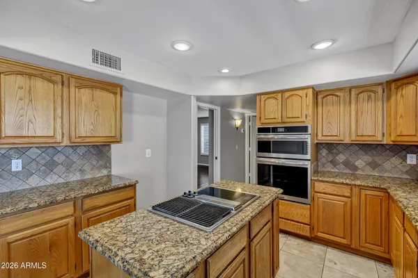 a spacious bathroom with a granite countertop double vanity sink a mirror and a shower