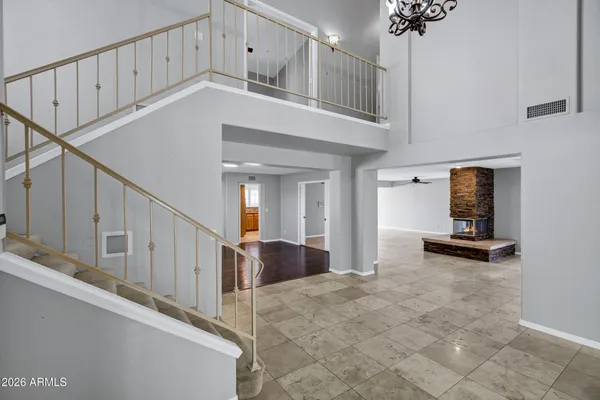 a view of an empty room with wooden floor and a ceiling fan