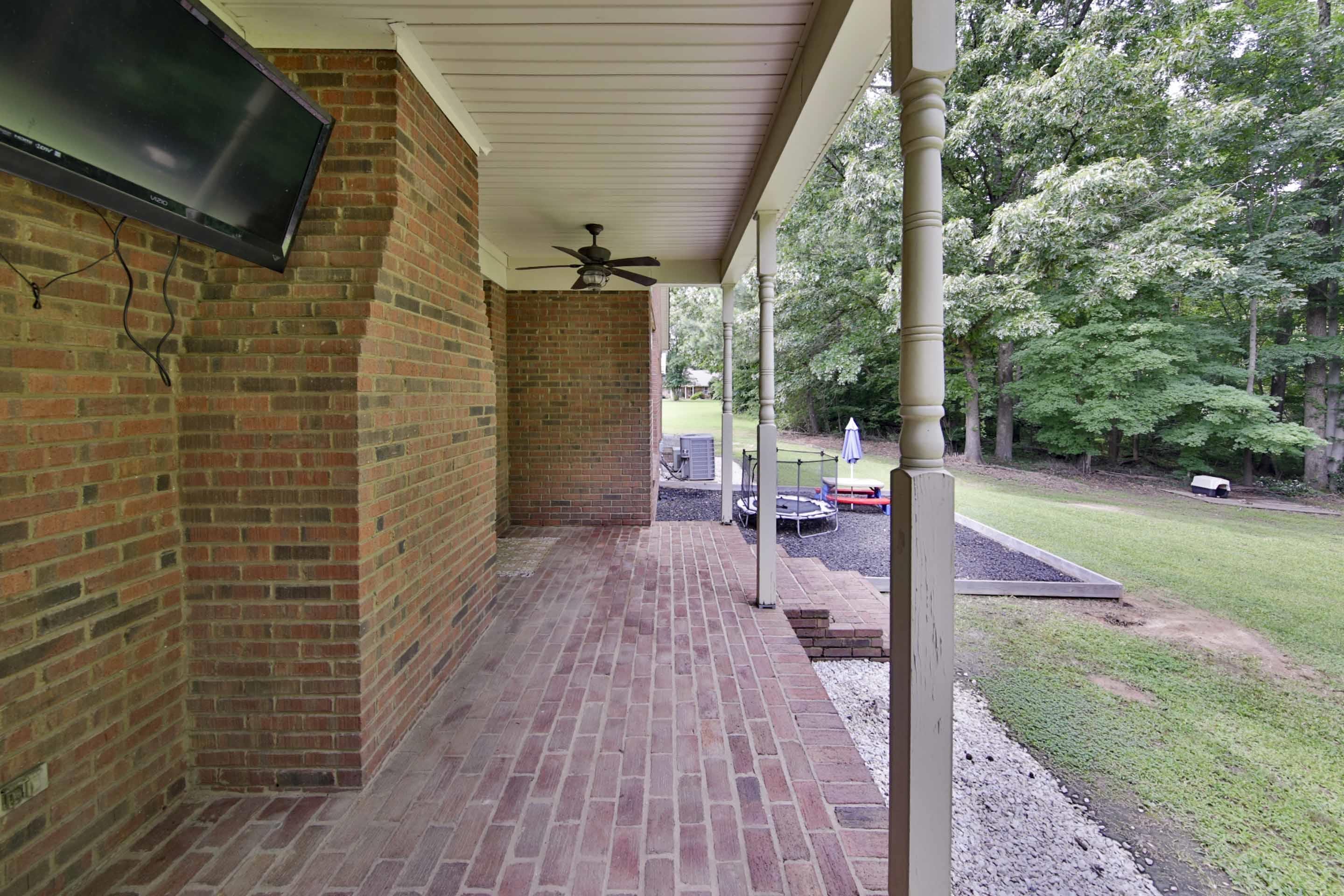 104 Miller Road Covington, TN 38019 - Photo 9 of 25 Brick paved porch featuring a ceiling fan, white paneled ceiling, and painted support columns