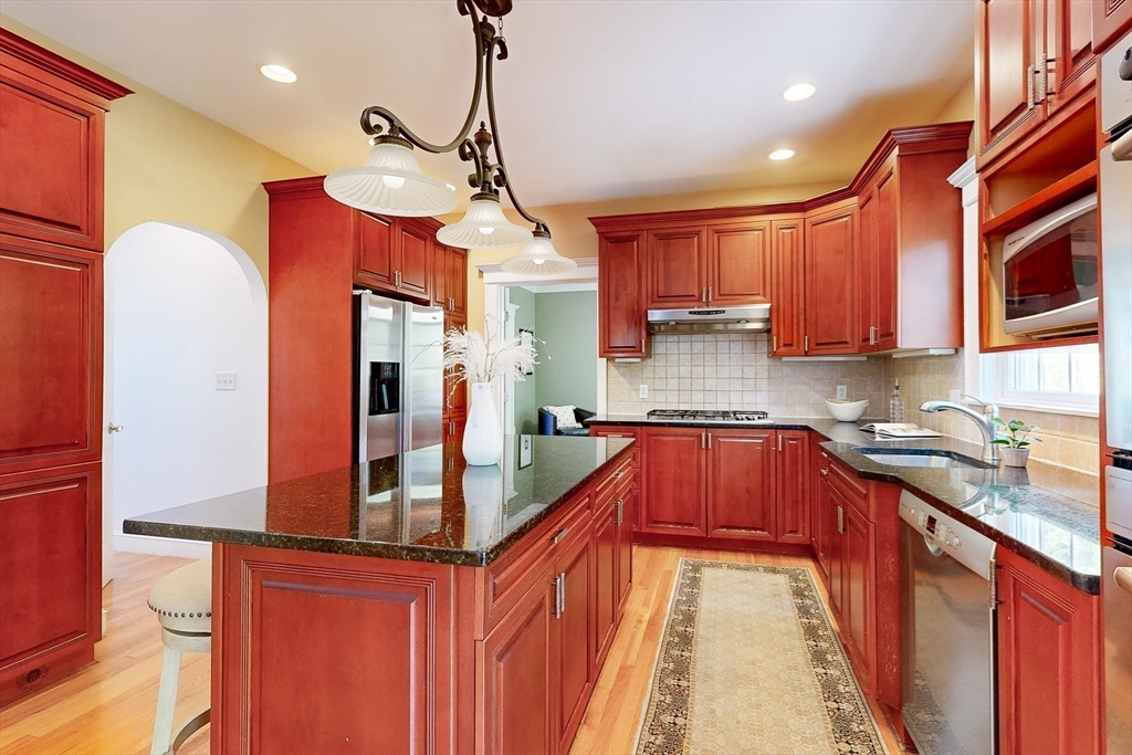 99 Ridge Street Winchester, MA 01890 - Photo 11 of 40 a kitchen with stainless steel appliances granite countertop a sink refrigerator and cabinets