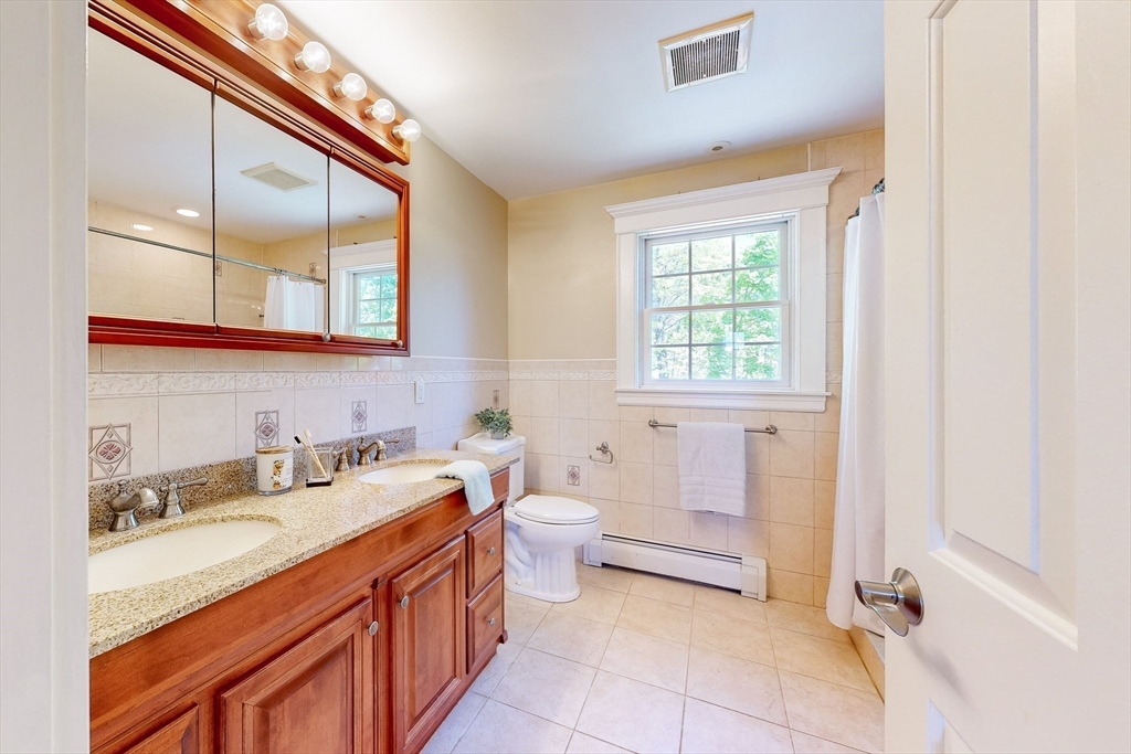 99 Ridge Street Winchester, MA 01890 - Photo 21 of 40 a spacious bathroom with a double vanity sink a mirror and a bathtub