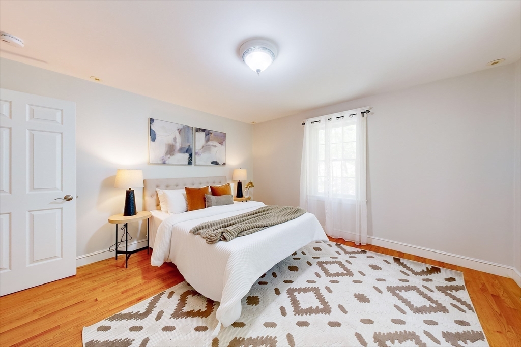 99 Ridge Street Winchester, MA 01890 - Photo 22 of 40 a bedroom with a bed and a chandelier