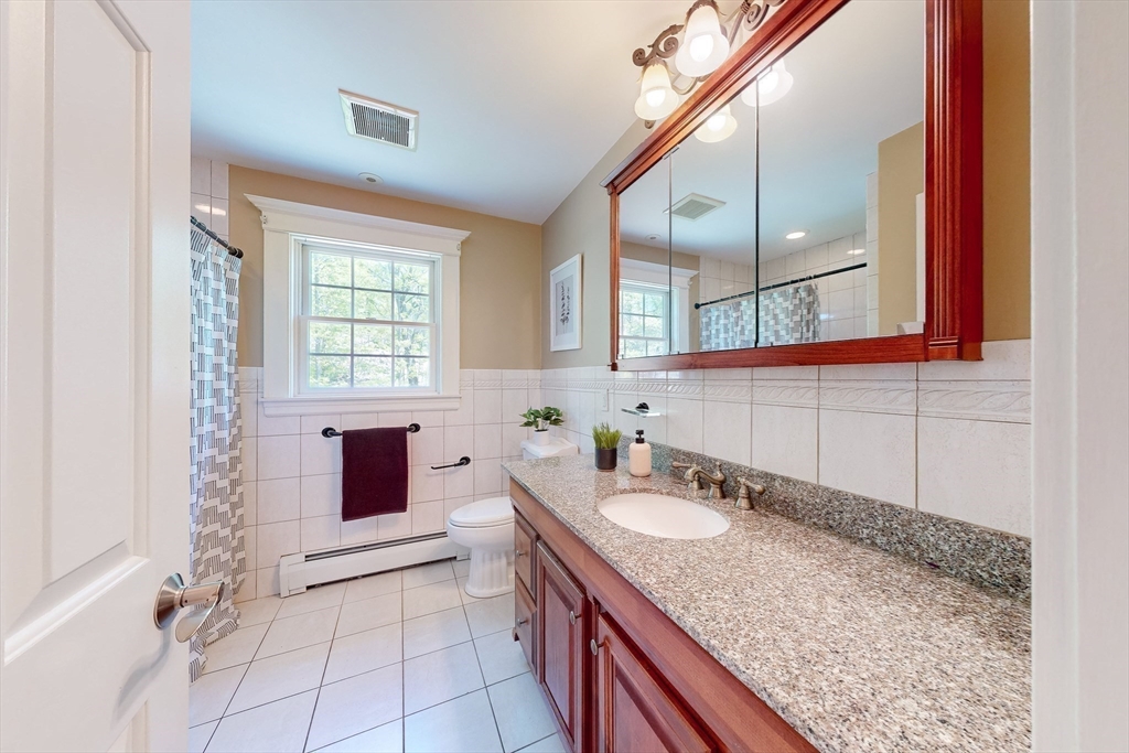 99 Ridge Street Winchester, MA 01890 - Photo 25 of 40 a spacious bathroom with a granite countertop sink and a mirror