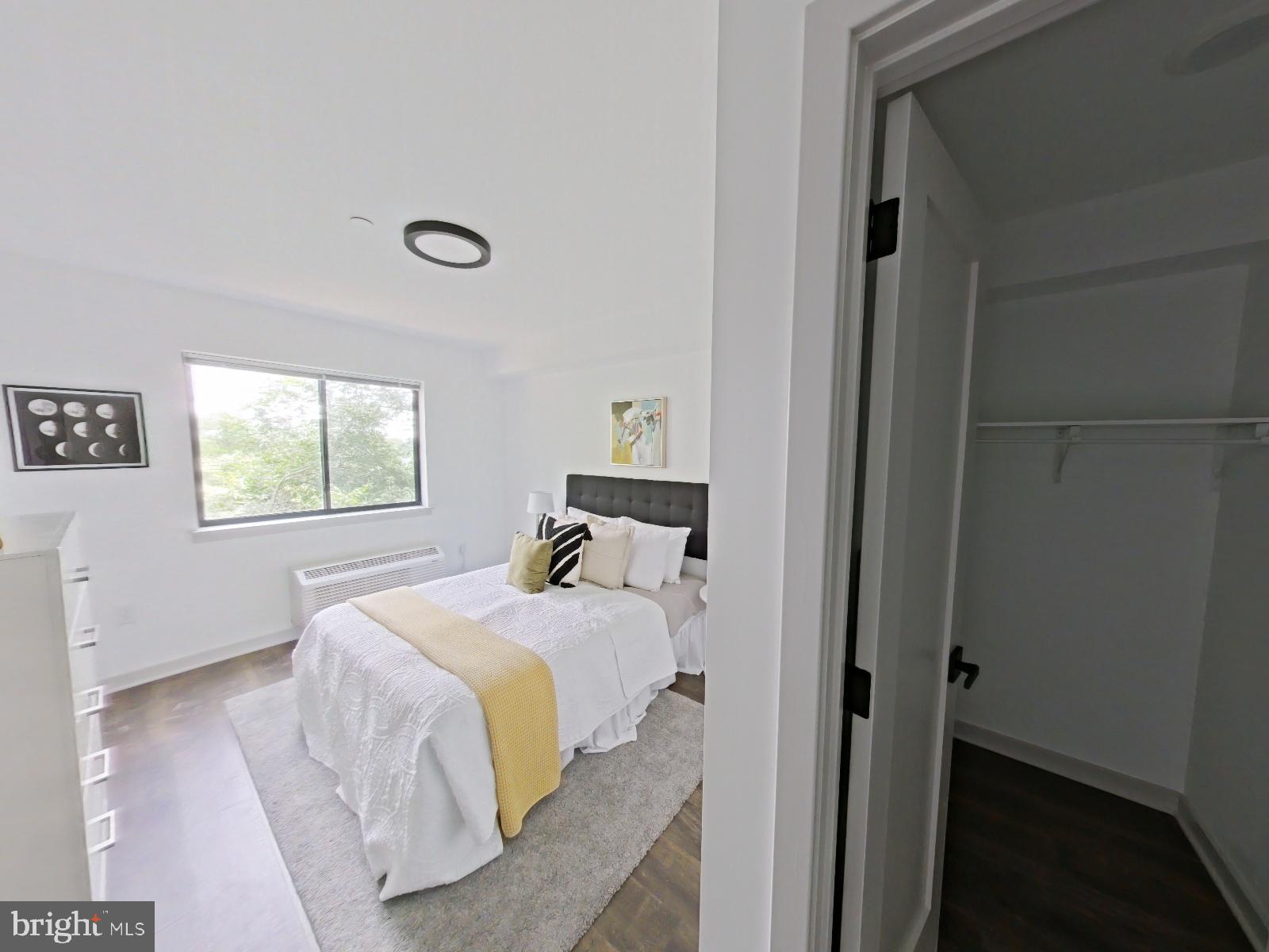 8327 Ridge Avenue, Unit 208 Philadelphia, PA 19128 - Photo 4 of 7 a bedroom with a bed and wooden floor
