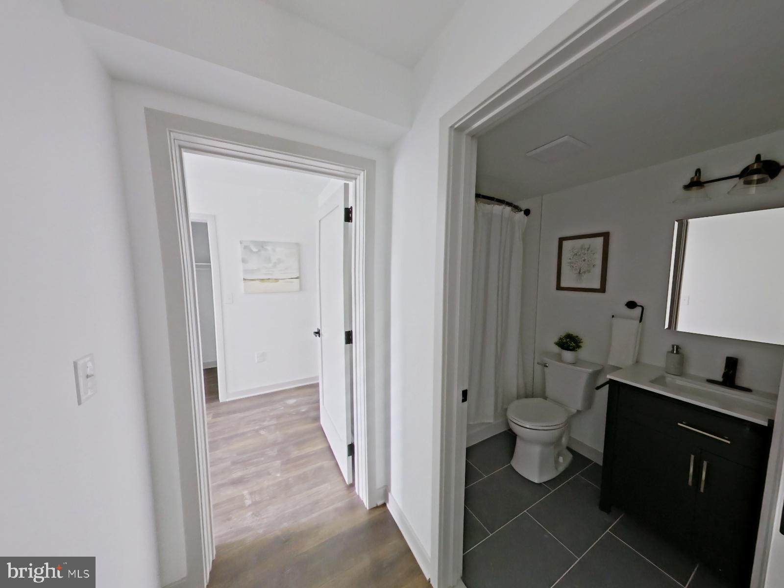 8327 Ridge Avenue, Unit 208 Philadelphia, PA 19128 - Photo 5 of 7 a bathroom with a toilet sink and a mirror