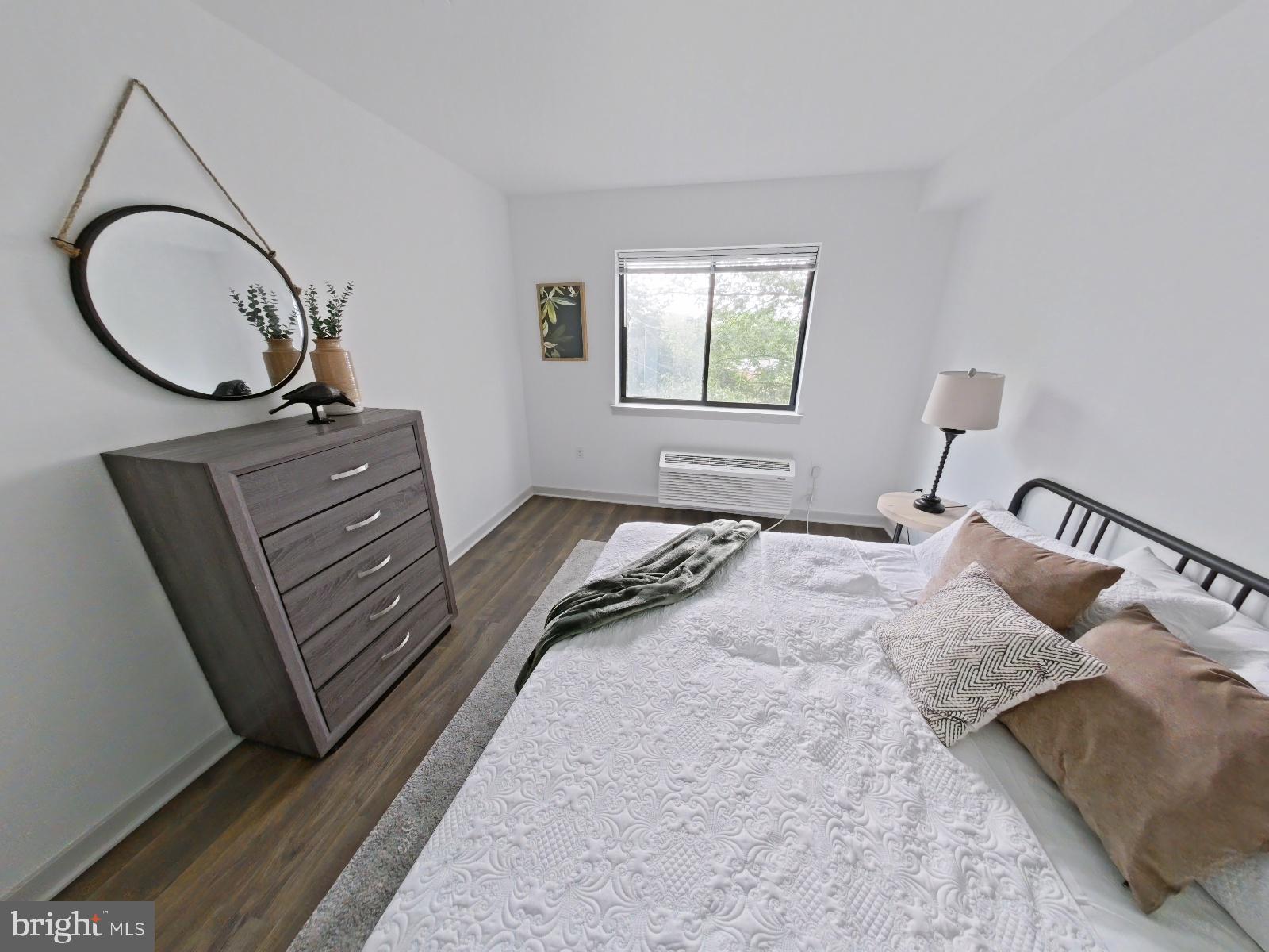 8327 Ridge Avenue, Unit 208 Philadelphia, PA 19128 - Photo 6 of 7 a bedroom with a bed and a dresser
