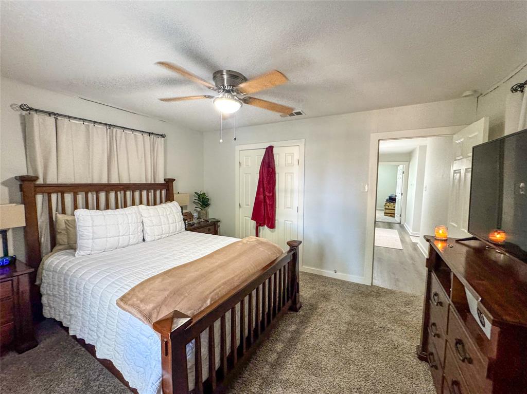 3206 Mitchell Street Greenville, TX 75402 - Photo 18 of 24 a bedroom with a bed and a chandelier