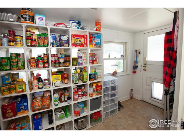 a room with fridge and a book shelf