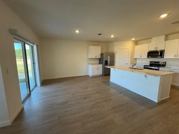 a kitchen with stainless steel appliances granite countertop a stove a sink and a refrigerator