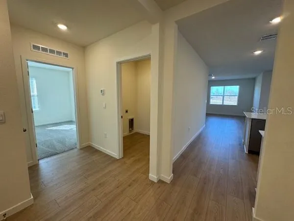 a view of a hallway with wooden floor and closet