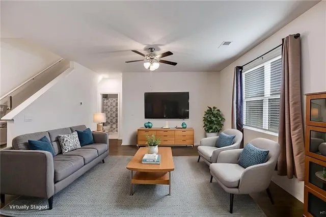 a living room with furniture ceiling fan and a window