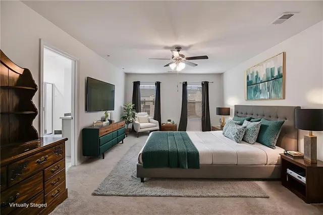 a spacious bedroom with a bed and a flat screen television