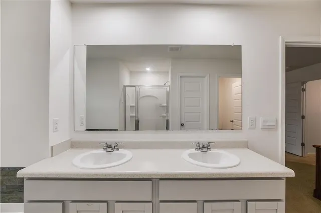 a bathroom with double sink and a mirror