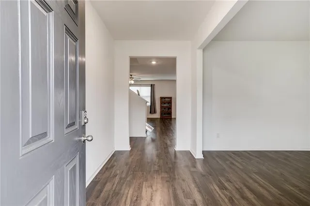a view of a hallway with wooden floor and staircase