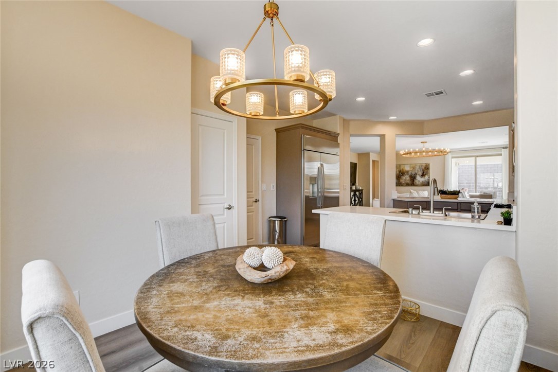 2649 Rue Marquette Avenue Henderson, NV 89044 - Photo 27 of 55 An inviting eat-in kitchen with a rustic circular table, a contemporary chandelier, and sleek stainless steel appliances.