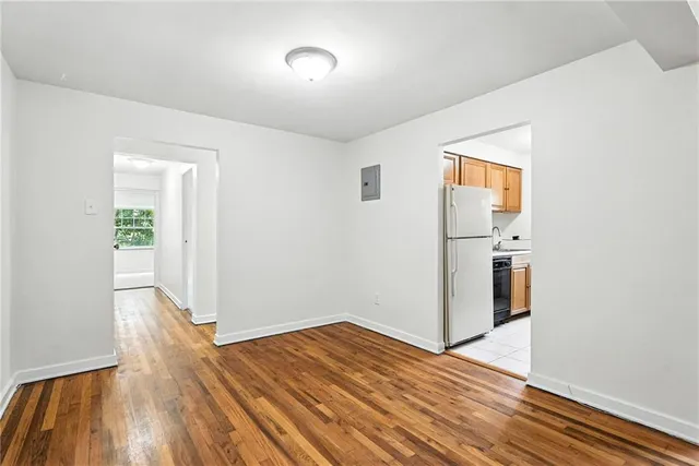 a view of empty room with wooden floor