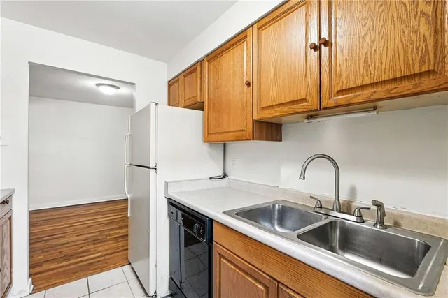a kitchen with stainless steel appliances granite countertop a sink a refrigerator and cabinets