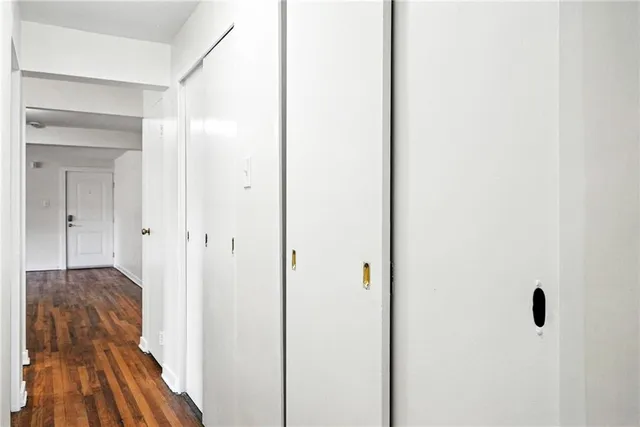 a view of a hallway with a closet and a mirror