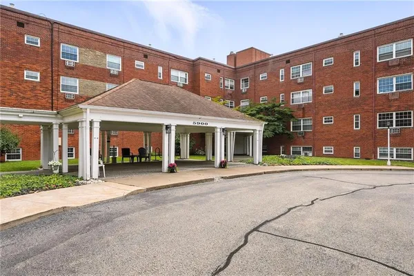 a front view of a building with a garden and plants