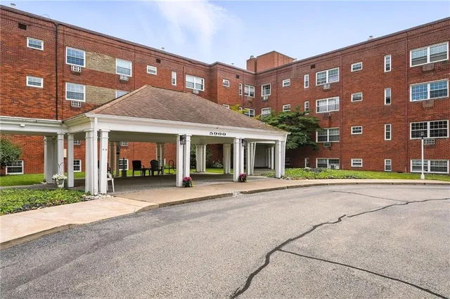 a front view of a building with a garden and plants