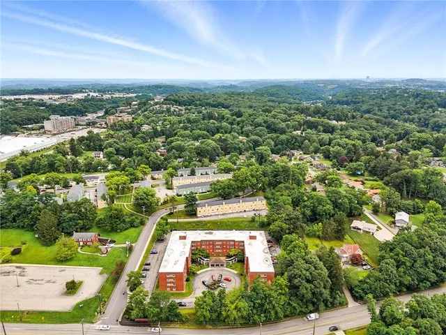 an aerial view of residential houses with outdoor space and trees