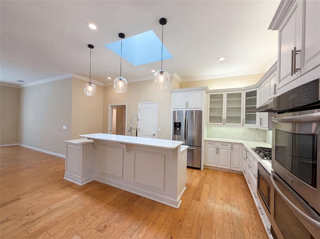 13478 Northwest 9 Road Newberry, FL 32669 - Photo 10 of 31 a large white kitchen with a stove a sink dishwasher and a refrigerator with wooden floor