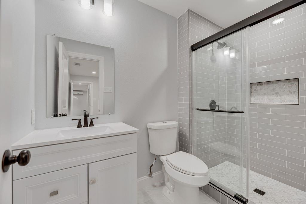 2015 Rose Hill Road Carrollton, TX 75007 - Photo 16 of 19 a bathroom with a sink toilet and shower