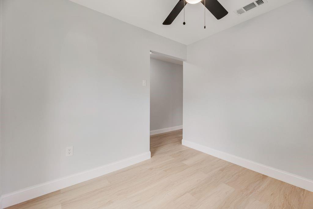 2015 Rose Hill Road Carrollton, TX 75007 - Photo 4 of 19 an empty room with a ceiling fan and wooden floor