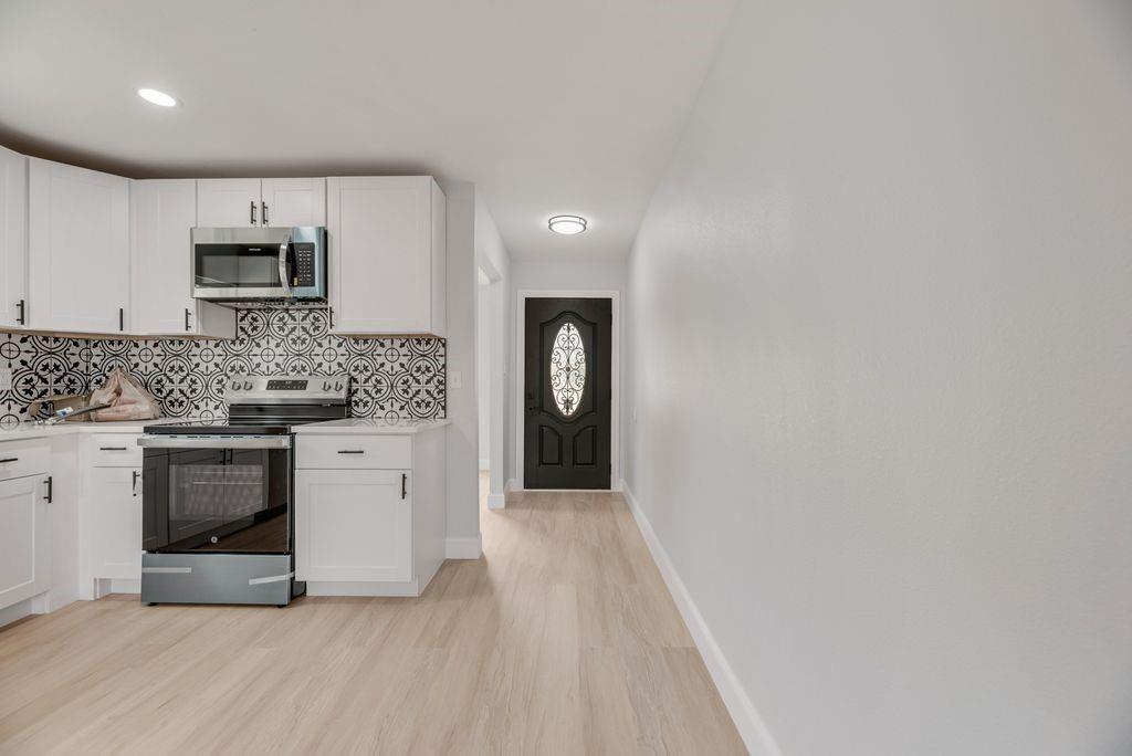 2015 Rose Hill Road Carrollton, TX 75007 - Photo 7 of 19 a kitchen with granite countertop white cabinets and stainless steel appliances
