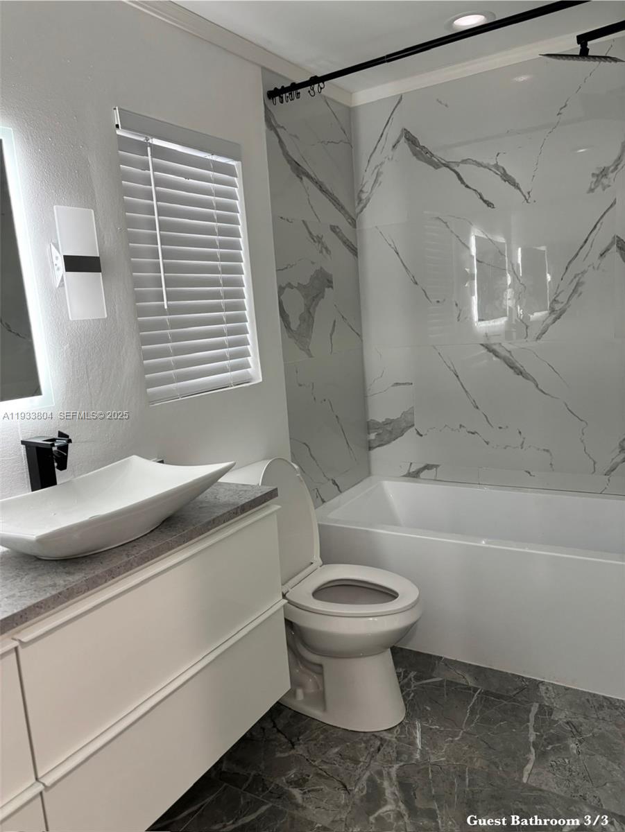 607 Maple Drive Margate, FL 33063 - Photo 23 of 37 a bathroom with a sink a toilet and a bathtub